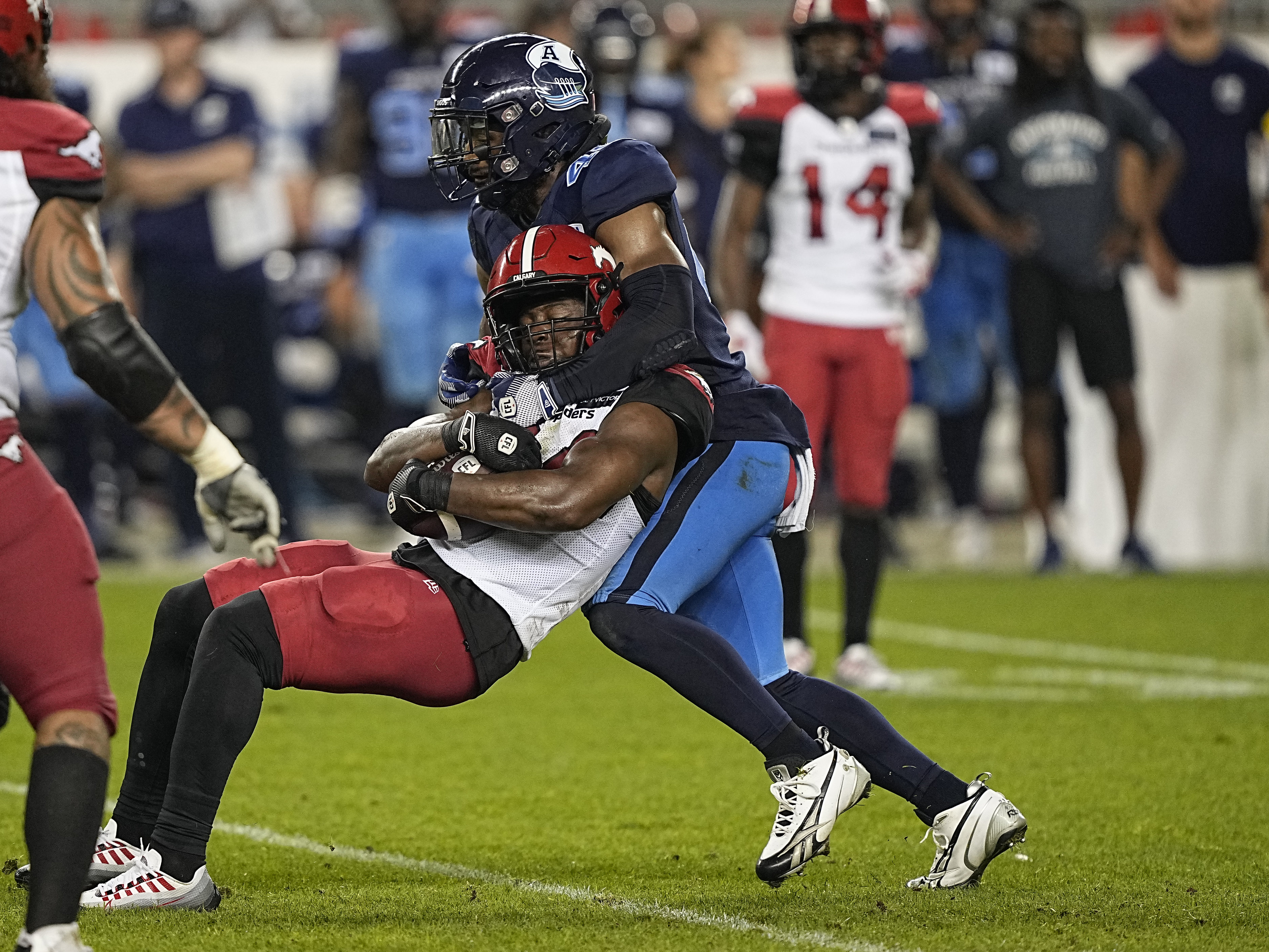 Aug 20, 2022; Toronto, Ontario, CAN; Toronto Argonauts linebacker Wynton McManis (48) tackles Calgary Stampeders running back Dedrick Mills (34) during the second half at BMO Field. Mandatory Credit: John E. Sokolowski-USA TODAY Sports